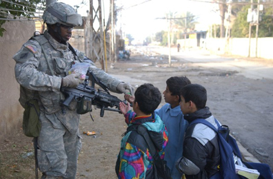 U.S. soldier giving candy to children